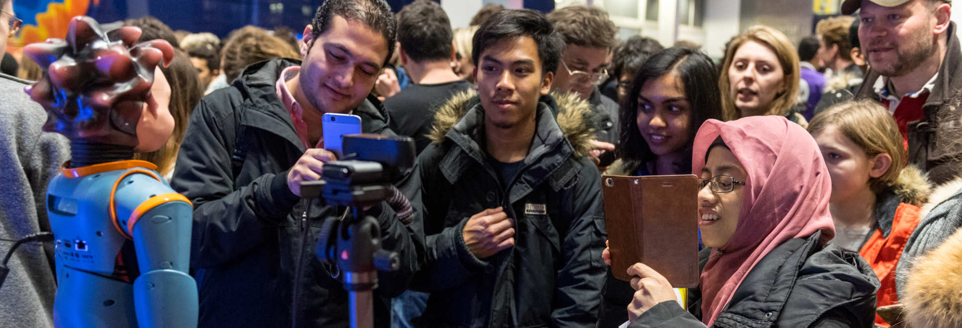 Members of the public take photographs of a robot at a Fringe event