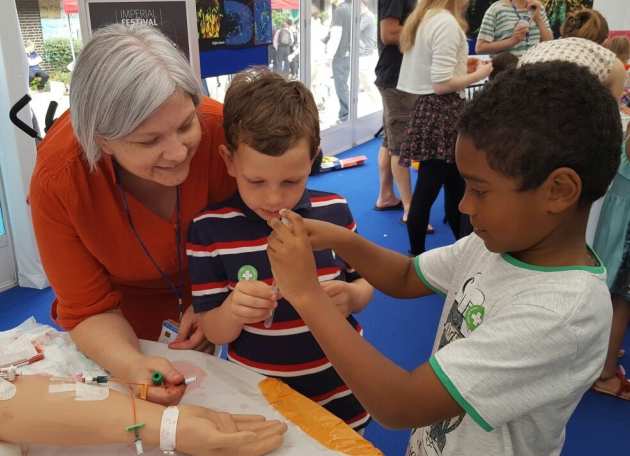 Research Nurse Debbie Papadopoulou demonstrating the kisspeptin team's clinical studies to local children