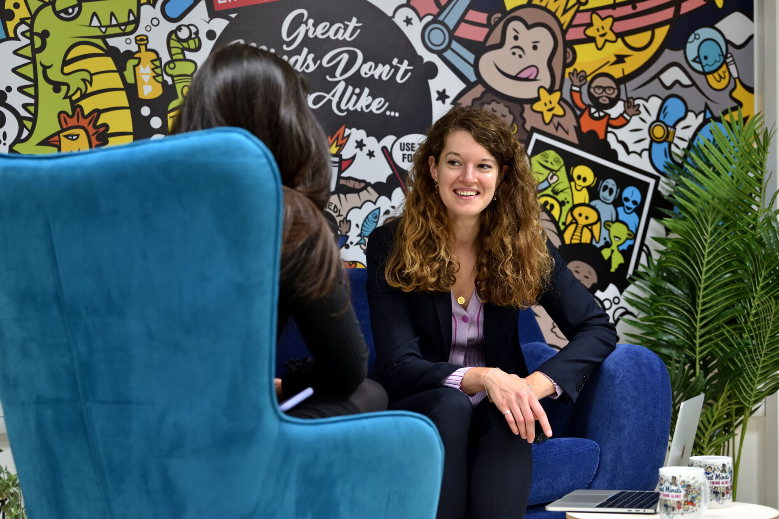 two women sat in arm chairs talking to each other